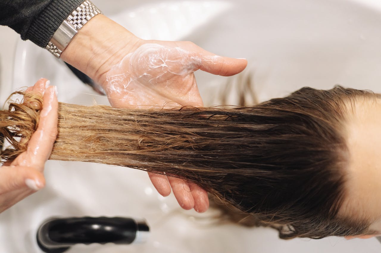 Home Close-up of a professional hair wash in a salon setting, highlighting hand technique.