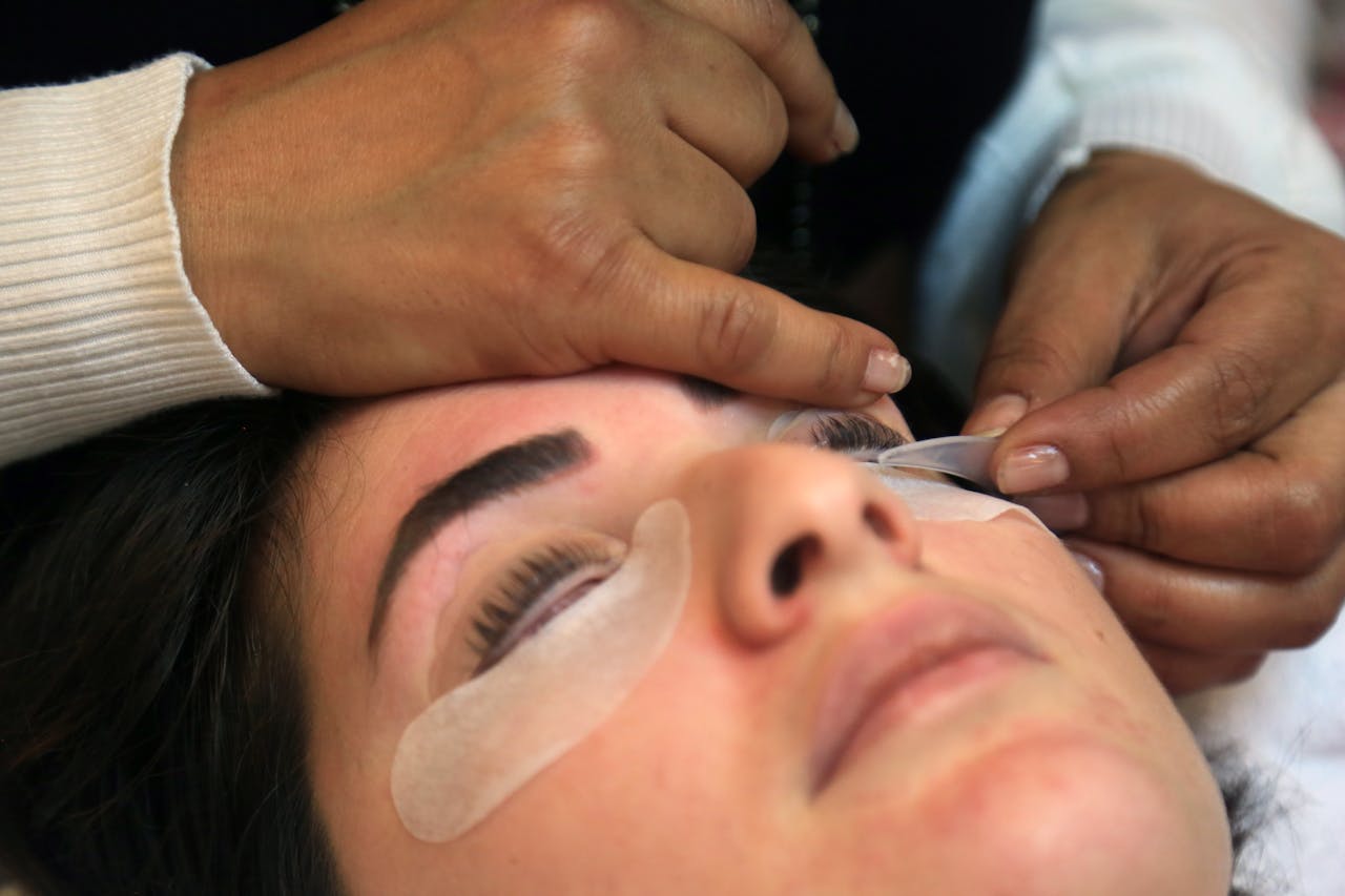 Home Close-up of a woman receiving an eyelash treatment in a spa setting, showcasing precision and care.